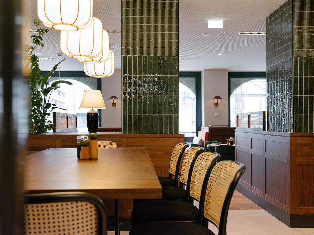 hanging lamps back dropped by wicker and wood and tiles in the feinkosterei restaurant interior design by archisphere in vienna photo copyright christof wagner