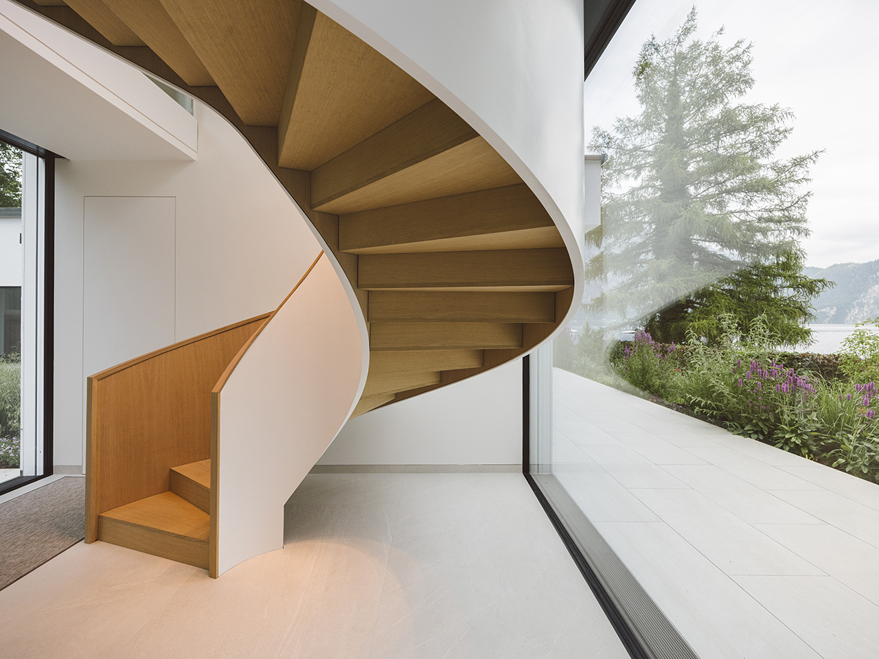 winded stair case with wood steps in a lake house designed by archisphere architects and interior designers in vienna photo copyright cristof wagner